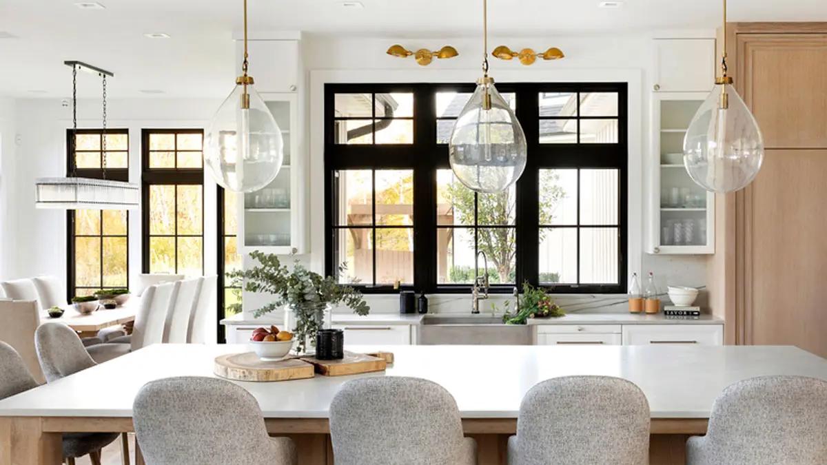 Kitchen with black-framed windows, white oak island, and brass pendant lighting